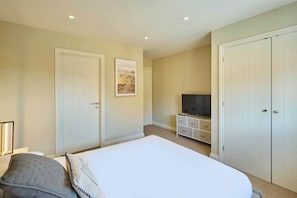 Ein Schlafzimmer mit Bett, Fernseher und Kleiderschrank.