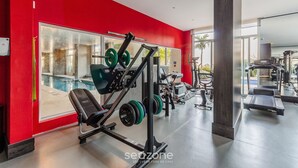 A gym with red walls, weightlifting equipment, and a treadmill. - Loft de luxo com Garagem no Petrópolis AHO1402 (Porto Alegre)