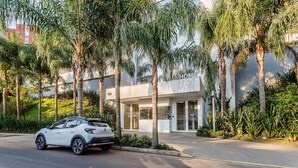 A modern building with a white facade and a gated entrance. - Loft de luxo com Garagem no Petrópolis AHO1402 (Porto Alegre)