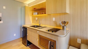 A modern kitchen with wooden cabinets, a built-in dishwasher, and a stainless steel sink. - Beautiful Units in the Auxiliadora Neighborhood in PoA - CEN (Porto Alegre)