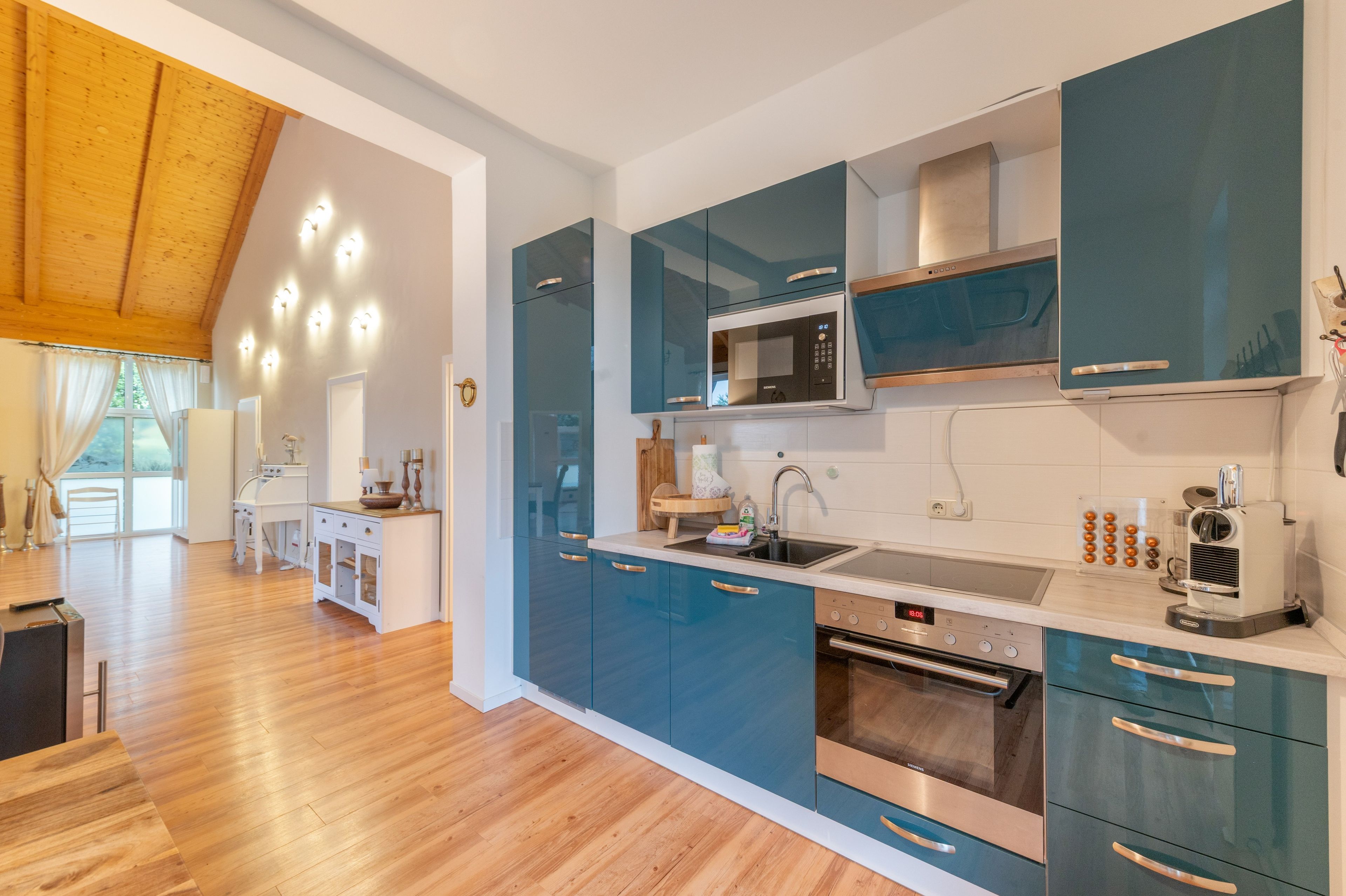 Una cucina moderna con forno integrato, microonde e macchina del caffè.