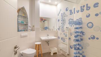 Un bagno con il WC, un lavandino e uno spazio doccia.