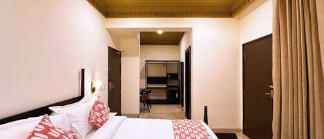 Una habitación de hotel con cama, escritorio y armario.