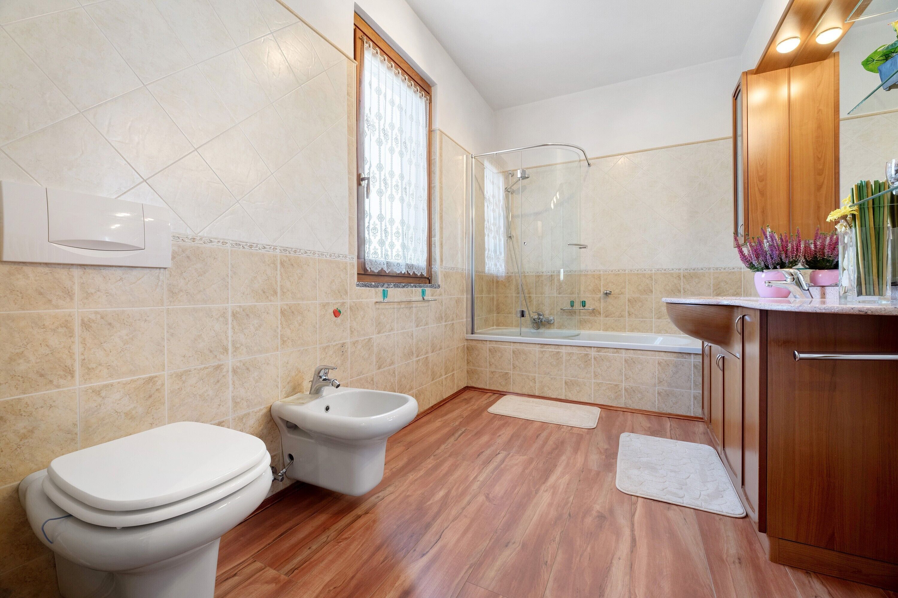 A bathroom with a toilet, bidet, shower, and bathtub.