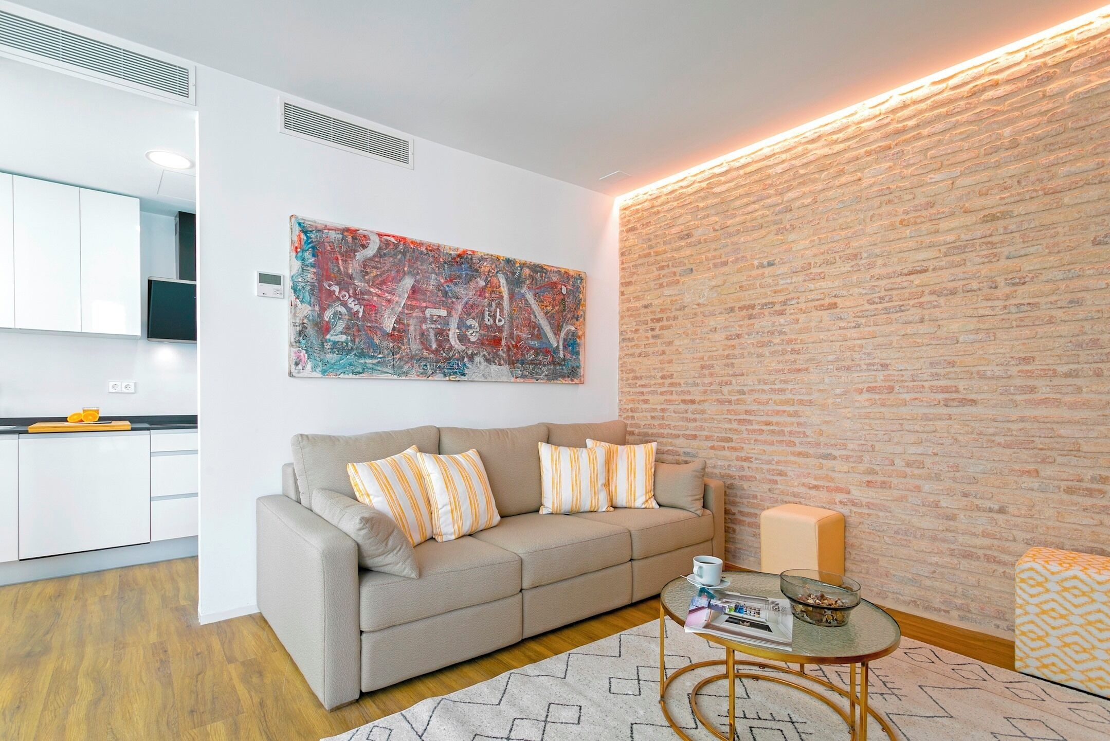 Una sala de estar moderna con un sofá, una mesa de centro y una pared de ladrillo decorativa.