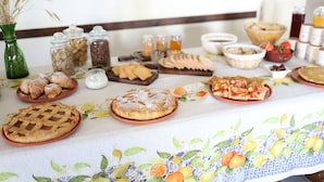 Ein Frühstücksbuffet mit verschiedenen Backwaren, Brot und Getränken.