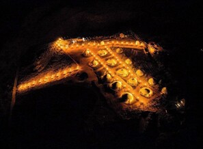 An aerial view of a well-lit, circular building complex at night.