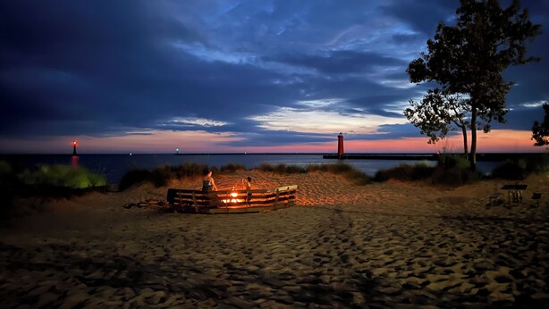 A beach with a wooden bench, a small fire pit, and a tree. - Lake Breeze Cottage 6 beds w AC, hot tub near Lake Michigan beach and The Deck. (Muskegon)