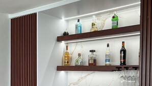A modern kitchen with a built-in wine rack, a wine cooler, and a wooden accent wall. - Ocean View Apartment in Condado (San Juan)