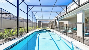 A swimming pool with a glass enclosure, surrounded by a deck and a fence. - 3613LL Windsor Island (Davenport)