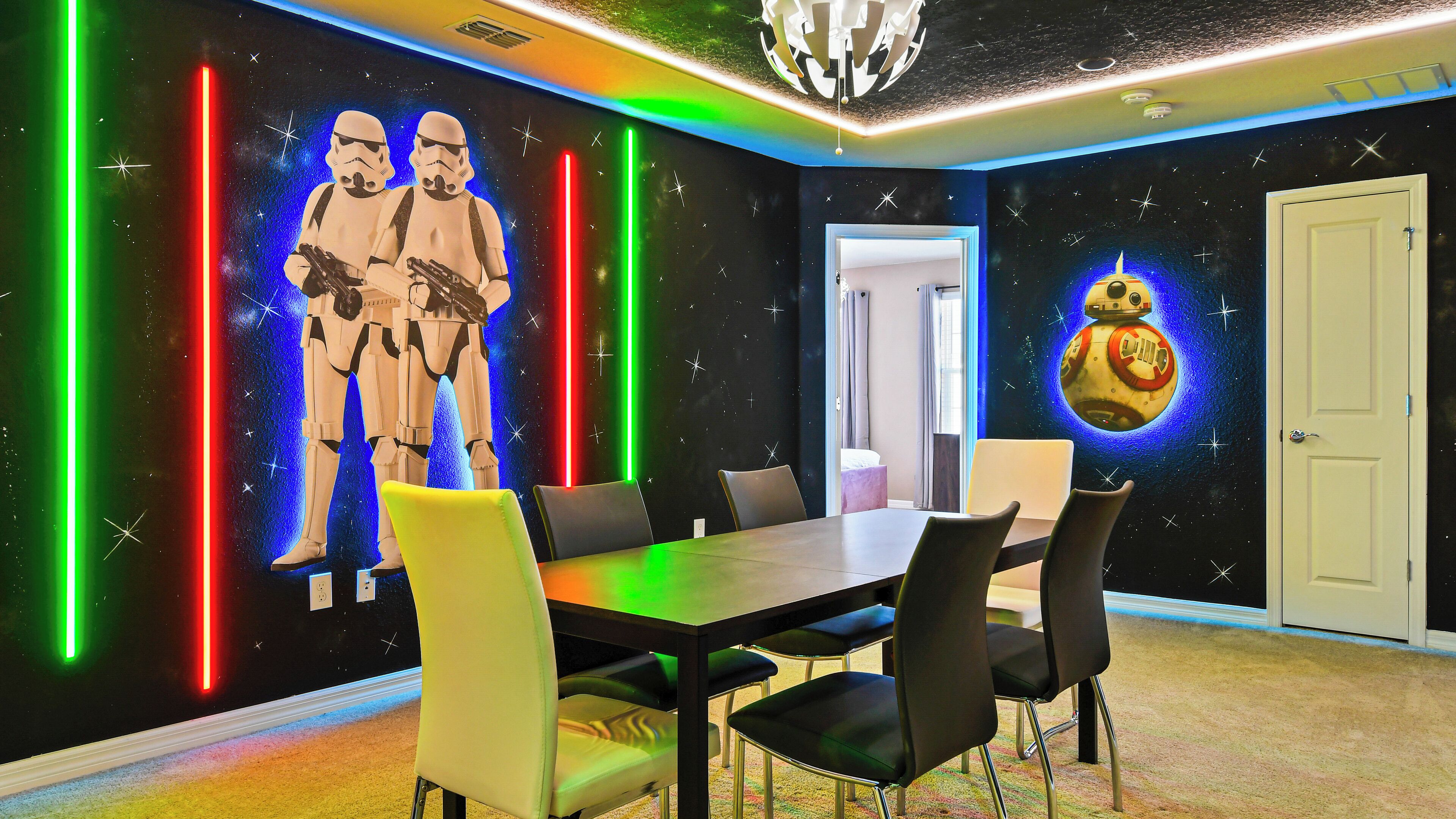 Ein Zimmer mit einer Wand im Star Wars-Design, einem Tisch und Stühlen.