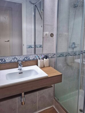 Een douche, handdoeken, zeep, shampoo