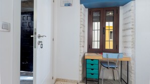 A room with a desk, chair, and a door leading to another room. - Apartment 'Doble Superior' with Wi-Fi and Air Conditioning (Sevilla)