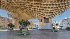 A spacious plaza with a distinctive architectural canopy, potted plants, and a clear sky. - Apartment 'Doble Superior' with Wi-Fi and Air Conditioning (Sevilla)