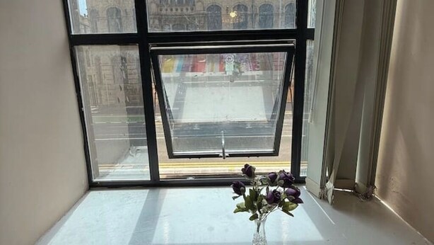 Una ventana con vista a un edificio y una calle.