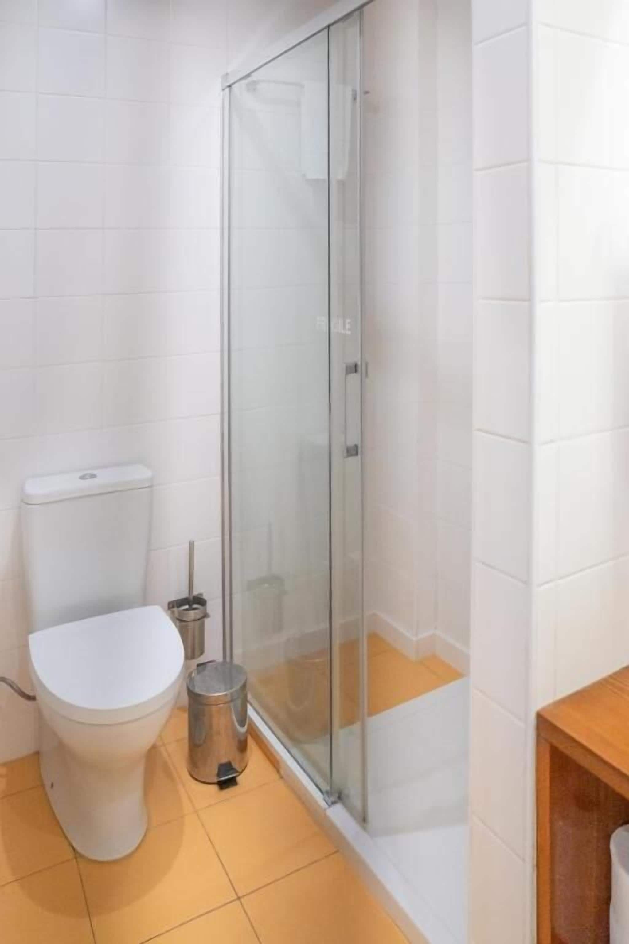 Deluxe appartement | Badkamer | Een douche, een haardroger, handdoeken, zeep