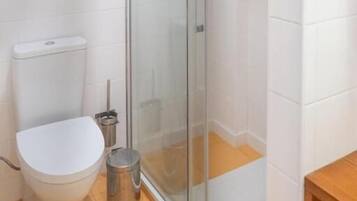 Deluxe appartement | Badkamer | Een douche, een haardroger, handdoeken, zeep