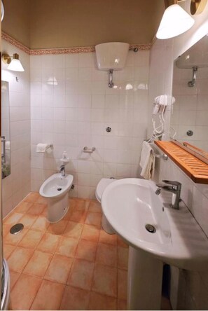 A bathroom with a bidet, a sink, a mirror, and a towel rack. - - Domus Lux - (Napoli)