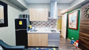 Una cocina compacta con microondas, refrigerador y pileta.