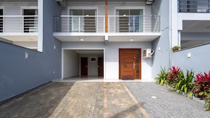 A modern building with a grey facade, a wooden door, and a balcony with metal railings. - House With Pool and Barbecue Ekd0397 (Picarras)