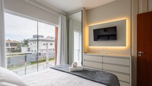 A modern hotel room with a large bed, a TV mounted on the wall, and a balcony with a view of the city. - House With Pool and Barbecue Ekd0397 (Picarras)