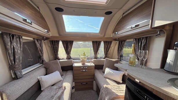 A cozy RV interior with a central seating area, a kitchen counter, and a dining table. - 4 Guests - Pet Friendly - Durham Caravan Retreat (Durham)