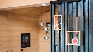 A wooden interior with a wooden-framed shelf holding a small figurine and a red object.