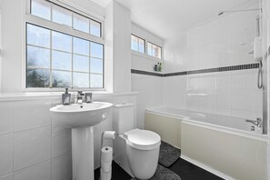 Tina con regadera, secadora de cabello, toallas, jabón