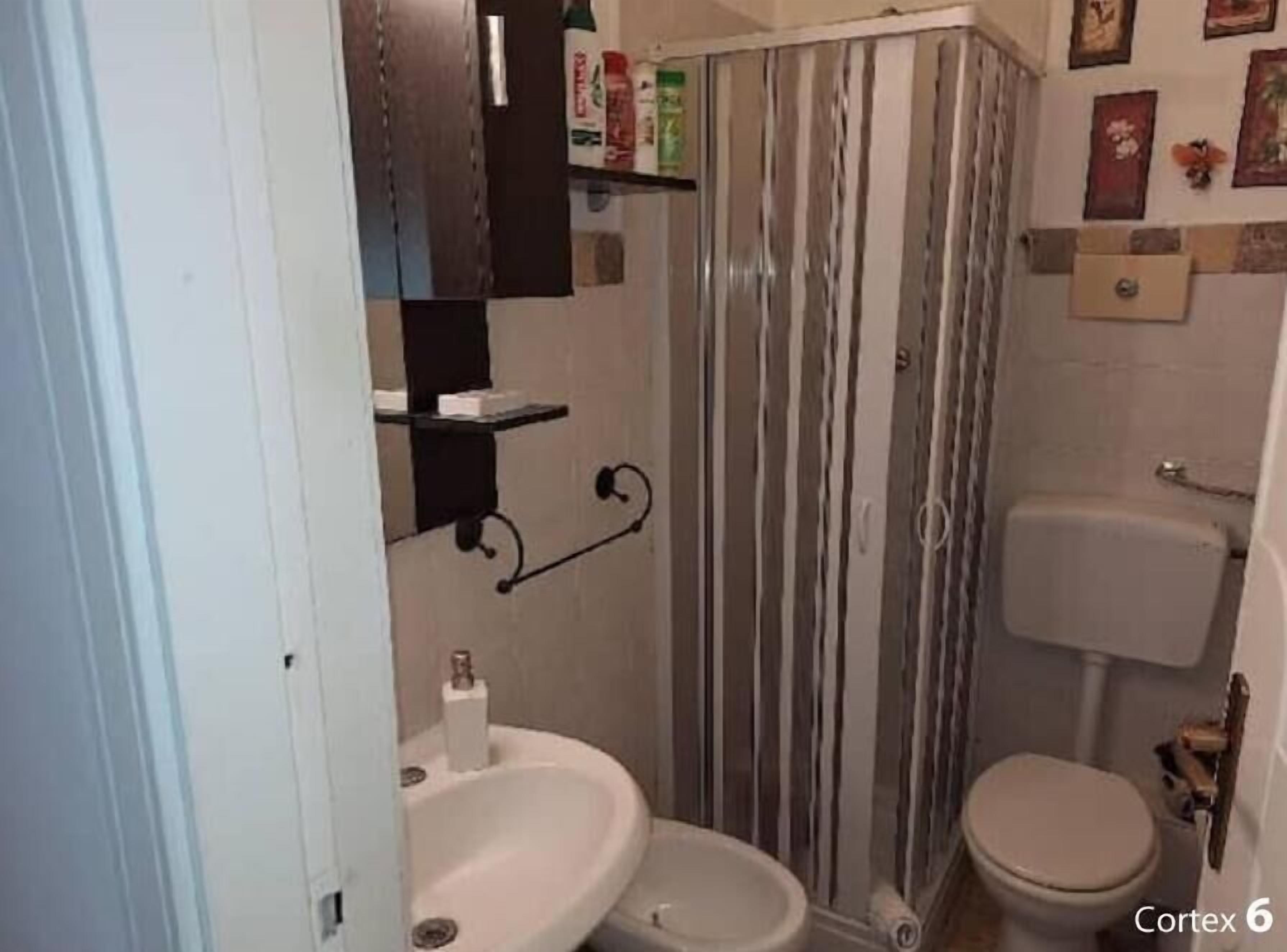 Un bagno compatto con doccia, toilette e lavandino.