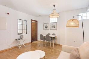 Una sala de estar moderna con comedor, un sofá, una mesa y una lámpara.