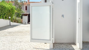 A white building with a closed door, a small window, and a metal handle. - Villa 'Ada' Independent with Wi-Fi and Air Conditioning (Golfo Aranci)