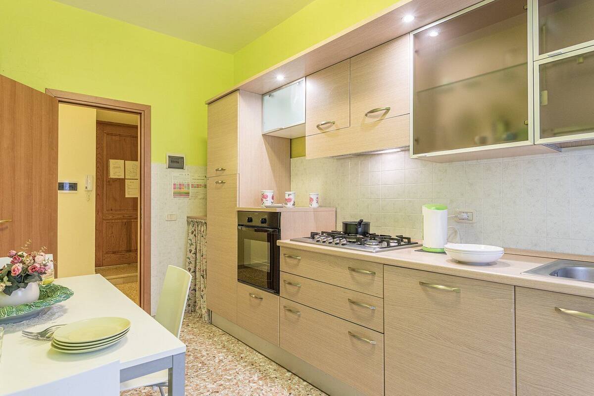 A compact kitchen with a gas stove, oven, and a small dining area with a table set for two.