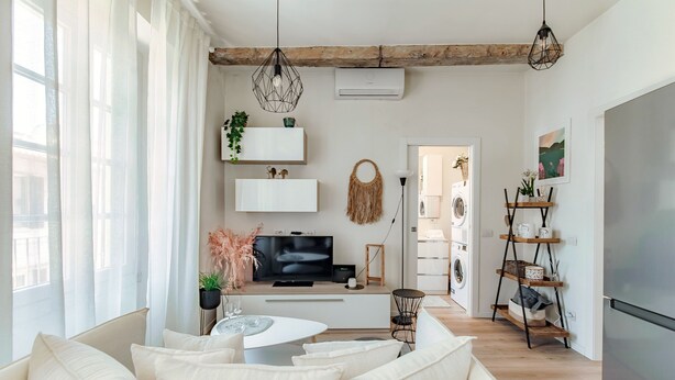A modern living room with a sofa, a coffee table, a TV, and a bookshelf. - Nest & Rest (Como)