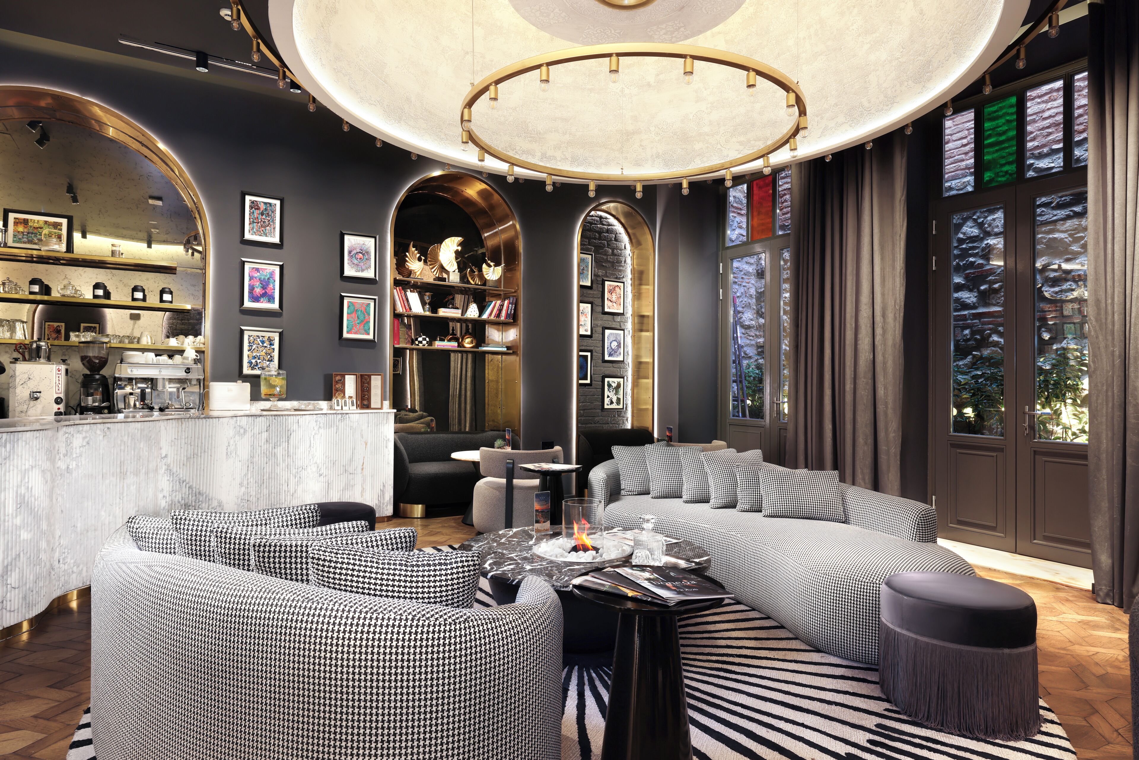 A modern interior with a bar area, seating with patterned upholstery, and a decorative ceiling.