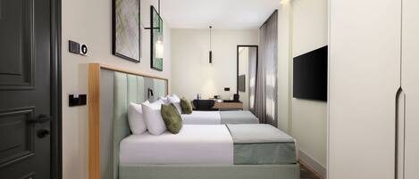 Une chambre d’hôtel avec deux lits, un bureau, un téléviseur à écran plat et un grand miroir.
