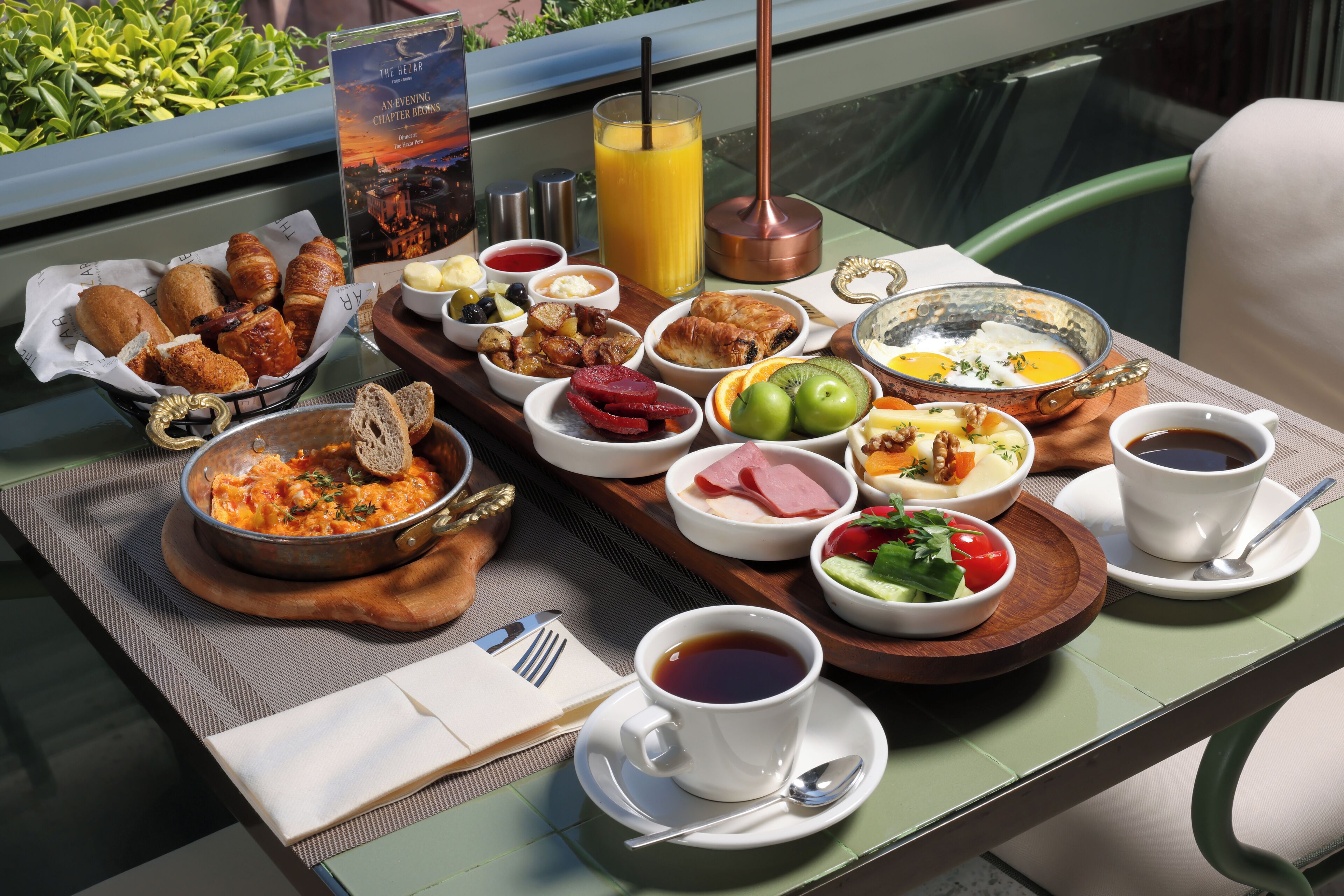 A table set with a variety of breakfast items including croissants, fruit, eggs, and coffee.