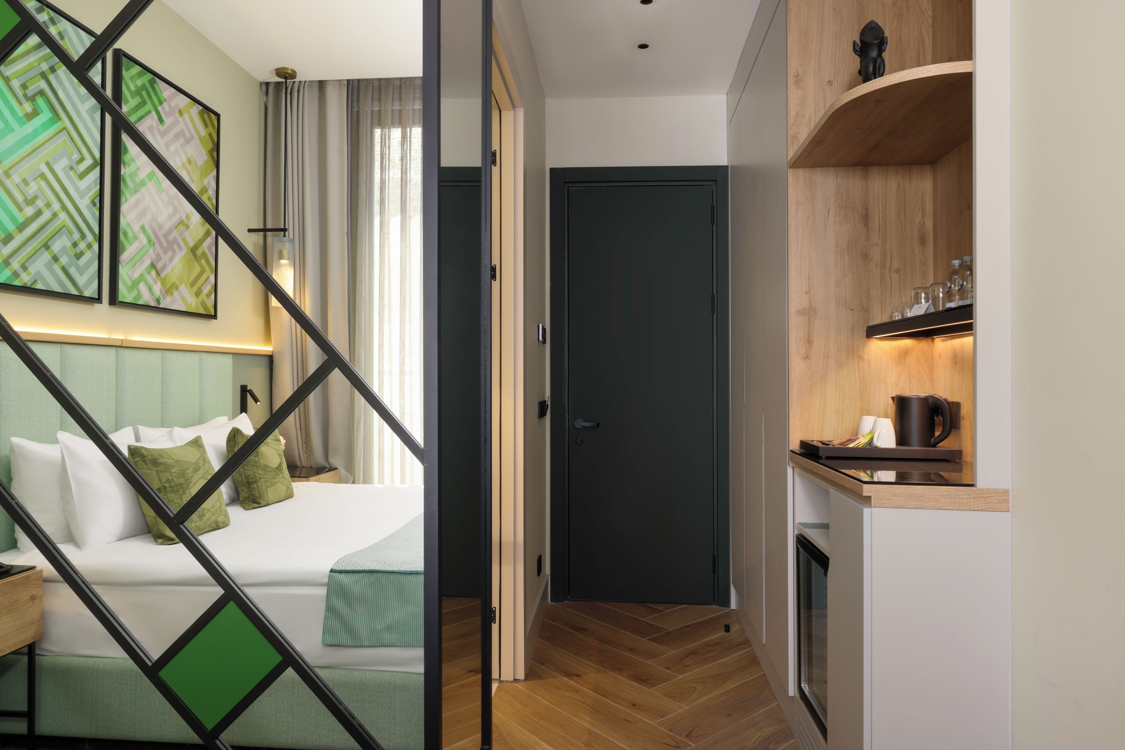 Habitación de hotel moderna con cama, escritorio y kitchenette.