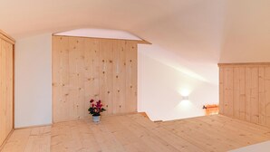 A room with wooden flooring, a sloped ceiling, and a wooden partition wall. - EnJoy Home - Attic with terrace in downtown/hospital area (Padova)