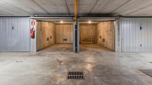 A spacious underground parking garage with concrete floors and walls, a central vertical pole, and a fire extinguisher on the left. - Facing San Siro Stadium 6 beds 300meters from the metro with garage (Milano)