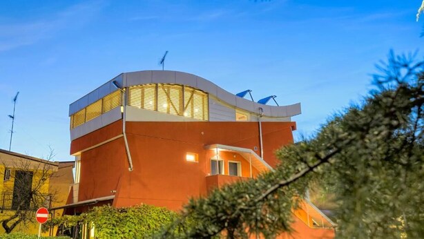 A modern building with a curved roof and a flat facade, featuring a prominent entrance and a staircase leading to an upper level. - Facing San Siro Stadium 6 beds 300meters from the metro with garage (Milano)