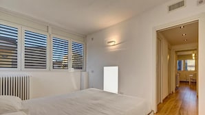 A bedroom with a bed, a radiator, and a window with blinds. - Facing San Siro Stadium 6 beds 300meters from the metro with garage (Milano)