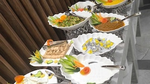 Une table de buffet avec divers plats et ustensiles.