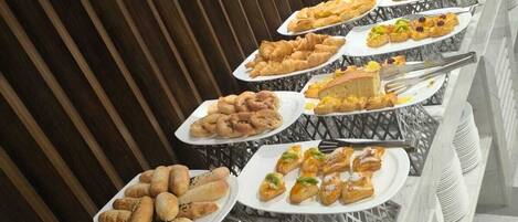 Ein Buffet mit verschiedenen Speisen, darunter Brot, Gebäck und Früchte.