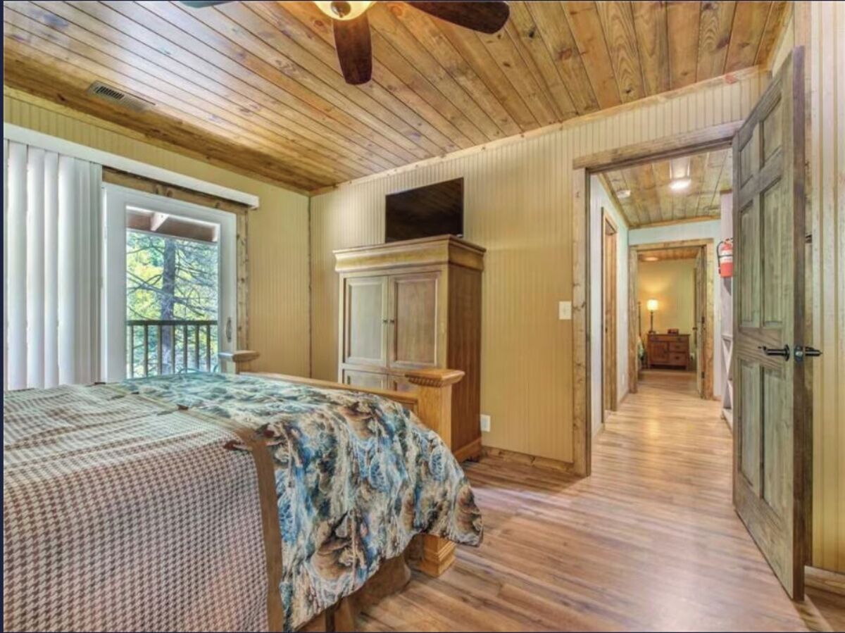 Une chambre à coucher avec un lit, une commode et un couloir menant à une autre pièce.