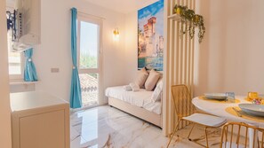 Une chambre moderne avec un lit, un coin repas comprenant une table et des chaises, et une salle de bain avec une douche.