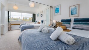 A hotel room with two beds, a view of the city, and artwork on the walls.