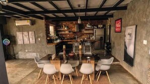 Una cocina moderna con una isla central, taburetes de bar y una gran mesa de comedor.