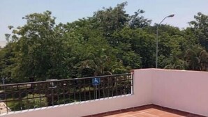Um terraço com piso de azulejos e guarda-corpo de metal.