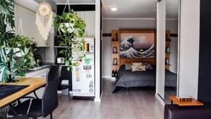 Un apartamento moderno con cocina, comedor y un dormitorio con un cuadro grande.