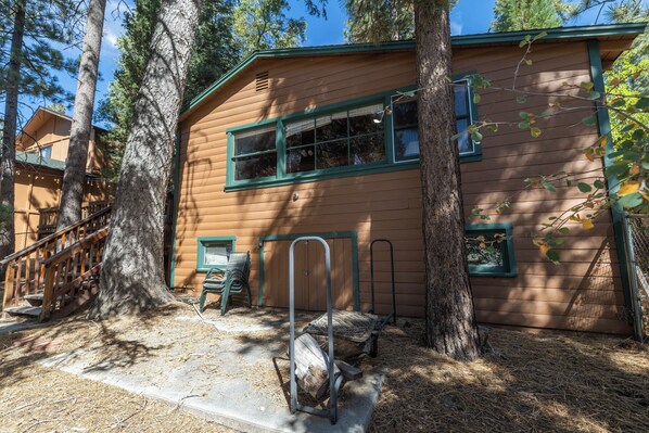 A wooden cabin with a porch, a bench, and a metal bench.